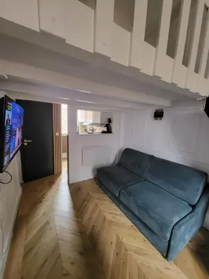 a living room with a couch and a tv at Studio Cosy Mezzanine 2-4p Carré d'Or in Nice