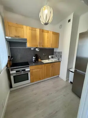 a kitchen with wooden cabinets and a stove top oven at Studio Lumiere Nice Center in Nice