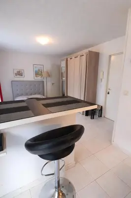 a bar stool in a room with a bed at Cocoon au calme, proche mer et centre ville in Nice