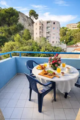 a table with a plate of food on a balcony at Cocoon au calme, proche mer et centre ville in Nice