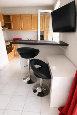 a kitchen with two black stools at a counter at Cocoon au calme, proche mer et centre ville in Nice