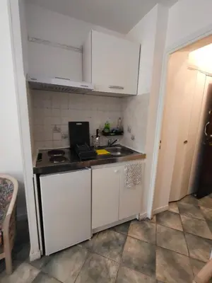 a small kitchen with white cabinets and a sink at Good studio in Nice