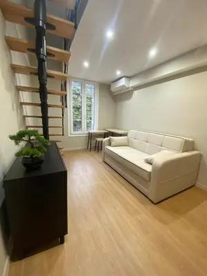 a living room with a white couch and a table at Duplex cosy sur Nice Libération in Nice