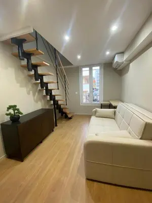 a living room with a couch and a staircase at Duplex cosy sur Nice Libération in Nice