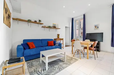 a living room with a blue couch and a table at Nice Renting - GRIMALDI - Golden Square Best Location Fully Equiped in Nice