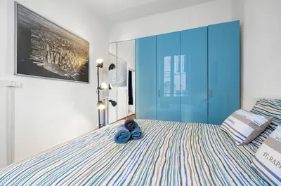 a bedroom with a bed with a pair of blue slippers on it at Nice Renting - GRIMALDI - Golden Square Best Location Fully Equiped in Nice