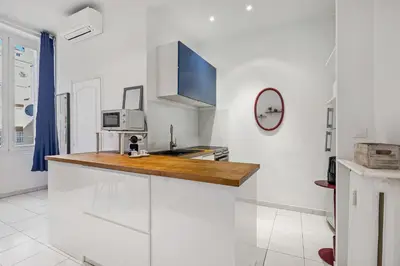 a kitchen with white walls and a wooden counter top at Nice Renting - GRIMALDI - Golden Square Best Location Fully Equiped in Nice
