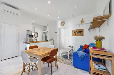 a living room with a table and a blue couch at Nice Renting - GRIMALDI - Golden Square Best Location Fully Equiped in Nice