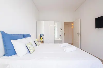 a bedroom with a large white bed with blue pillows at Perfect Location downtown - elegant apartment in Nice