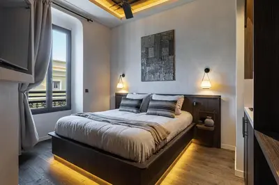a bedroom with a bed with two pillows and a window at Wabi-Sabi Hôtel Lorrain in Nice