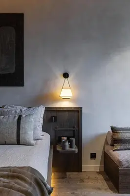 a bedroom with a bed and a light on the wall at Wabi-Sabi Hôtel Lorrain in Nice