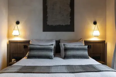a bedroom with a bed with two pillows and two lights at Wabi-Sabi Hôtel Lorrain in Nice