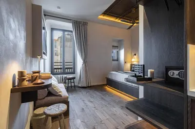 a hotel room with a bed and a living room at Wabi-Sabi Hôtel Lorrain in Nice