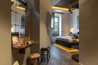 a living room with a bed and a room with a table at Wabi-Sabi Hôtel Lorrain in Nice