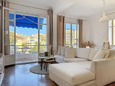 a living room with a white couch and a large window at Large 2 bedroom apartment, Close to Promenade des Anglais in Nice