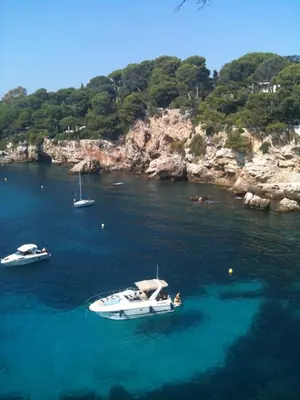 three boats in the water near a rocky island at Nice Petite maison mitoyenne avec piscine in La Gaude