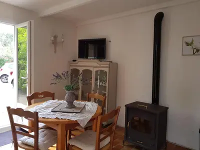 a dining room with a table and a wood stove at Nice Petite maison mitoyenne avec piscine in La Gaude