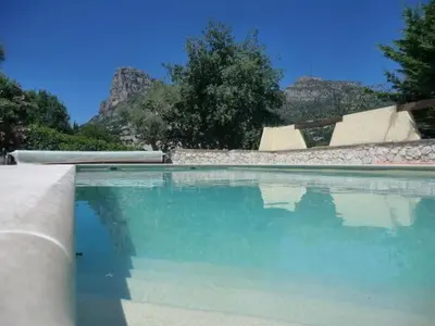 a pool of blue water with mountains in the background at Nice Petite maison mitoyenne avec piscine in La Gaude