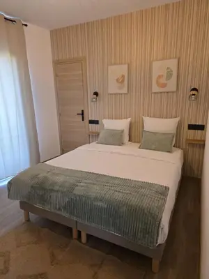a bedroom with a large white bed with two pillows at La costière in Nice