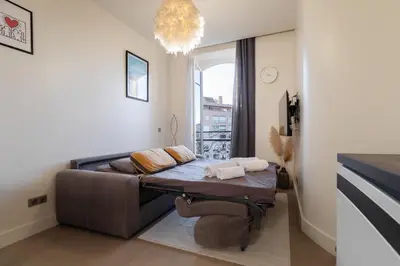 a living room with a couch and a chandelier at Maison Bianchi - Studio on avenue Jean Medecin in Nice