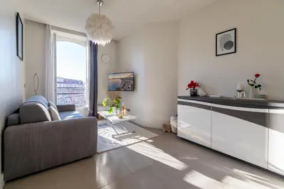 a living room with a couch and a large window at Maison Bianchi - Studio on avenue Jean Medecin in Nice