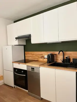 a kitchen with white cabinets and a stove top oven at Charming 2 rooms with balcony in Nice
