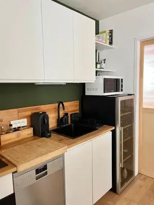 a kitchen with white cabinets and a sink at Charming 2 rooms with balcony in Nice