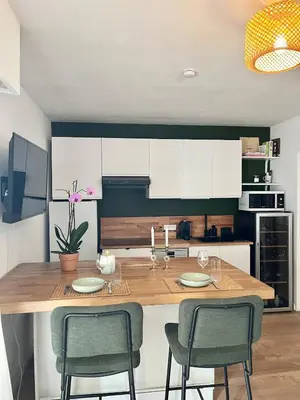 a kitchen with a counter with two chairs and a table at Charming 2 rooms with balcony in Nice