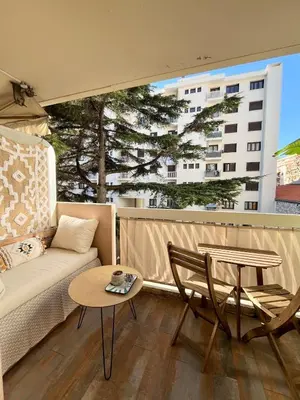 a living room with a couch and a table at Charming 2 rooms with balcony in Nice