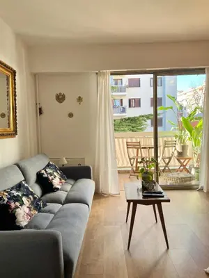 a living room with a couch and a table at Charming 2 rooms with balcony in Nice
