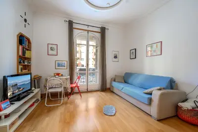 a living room with a blue couch and a tv at LX196 Studio mezzanine balcon Tram plage à pied in Nice