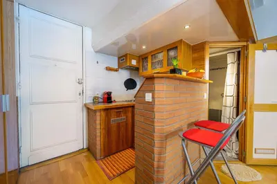 a kitchen with a brick wall and a red stool at LX196 Studio mezzanine balcon Tram plage à pied in Nice
