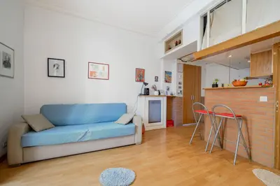 a living room with a blue couch and a kitchen at LX196 Studio mezzanine balcon Tram plage à pied in Nice
