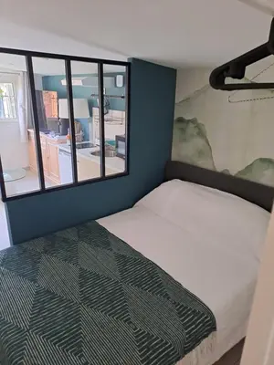 a bed in a room with a window at Studio dans le vert in Nice