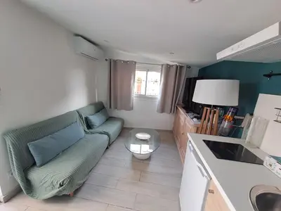 a living room with a couch and a table at Studio dans le vert in Nice