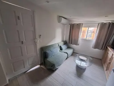 a living room with a chair and a glass table at Studio dans le vert in Nice