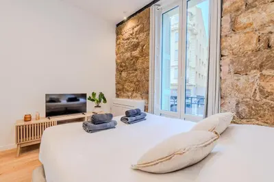 a bedroom with a white bed and a large window at Dolce Vita - Studio Centre Nice in Nice