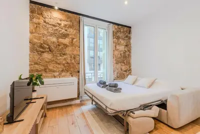 a bedroom with a bed and a tv and a brick wall at Dolce Vita - Studio Centre Nice in Nice
