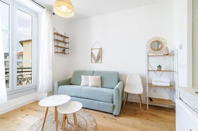 a living room with a blue couch and two tables at Charming City Center Studio 402 in Nice