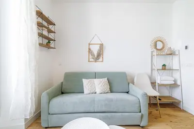a blue couch with two pillows on it in a living room at Charming City Center Studio 402 in Nice