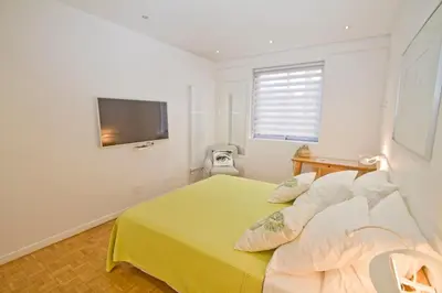 a bedroom with a yellow bed with a television on the wall at Le Copacabana Riviera in Nice