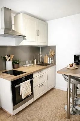 a kitchen with white cabinets and a stove top oven at CALIF52 appartement avec terrasse à 3 min de la plage,1min tram in Nice