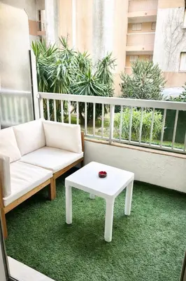 a couch and a coffee table on a balcony at CALIF52 appartement avec terrasse à 3 min de la plage,1min tram in Nice