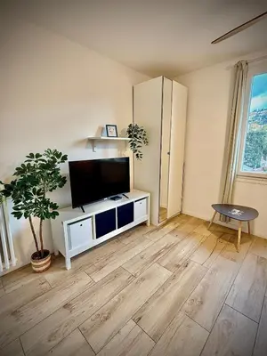 a living room with a flat screen tv on a white cabinet at Charmant studio pour amoureux in Nice