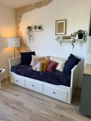 a bedroom with a white bed with pillows on it at Charmant studio pour amoureux in Nice