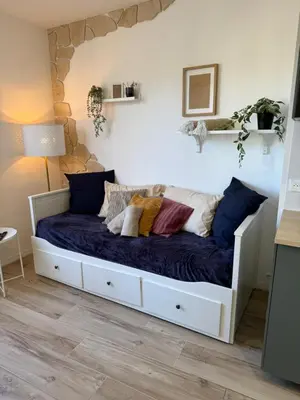 a bed with pillows on it in a room at Charmant studio pour amoureux in Nice