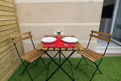 a picnic table with two chairs and a red napkin at Le Valrose - Calme & Terrasse in Nice