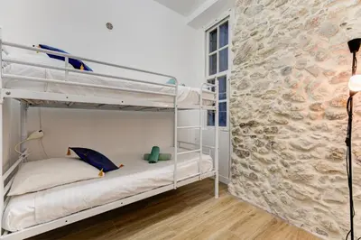 a bedroom with two bunk beds and a stone wall at Vieille Ville - parking, 5 pers, AC, WIFI in Nice