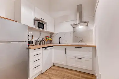 a kitchen with white cabinets and a refrigerator at Vieille Ville - parking, 5 pers, AC, WIFI in Nice