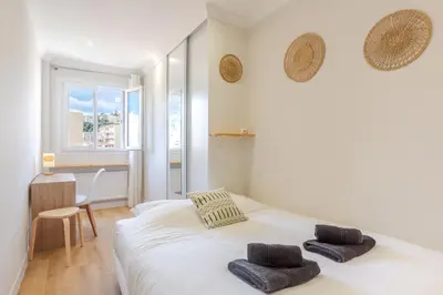 a bedroom with a white bed with two pillows on it at Nice - SweetHome Spacious Flat - Balcon in Nice